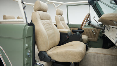Tan floor mats and pedals inside Classic Ford Bronco with beige interior