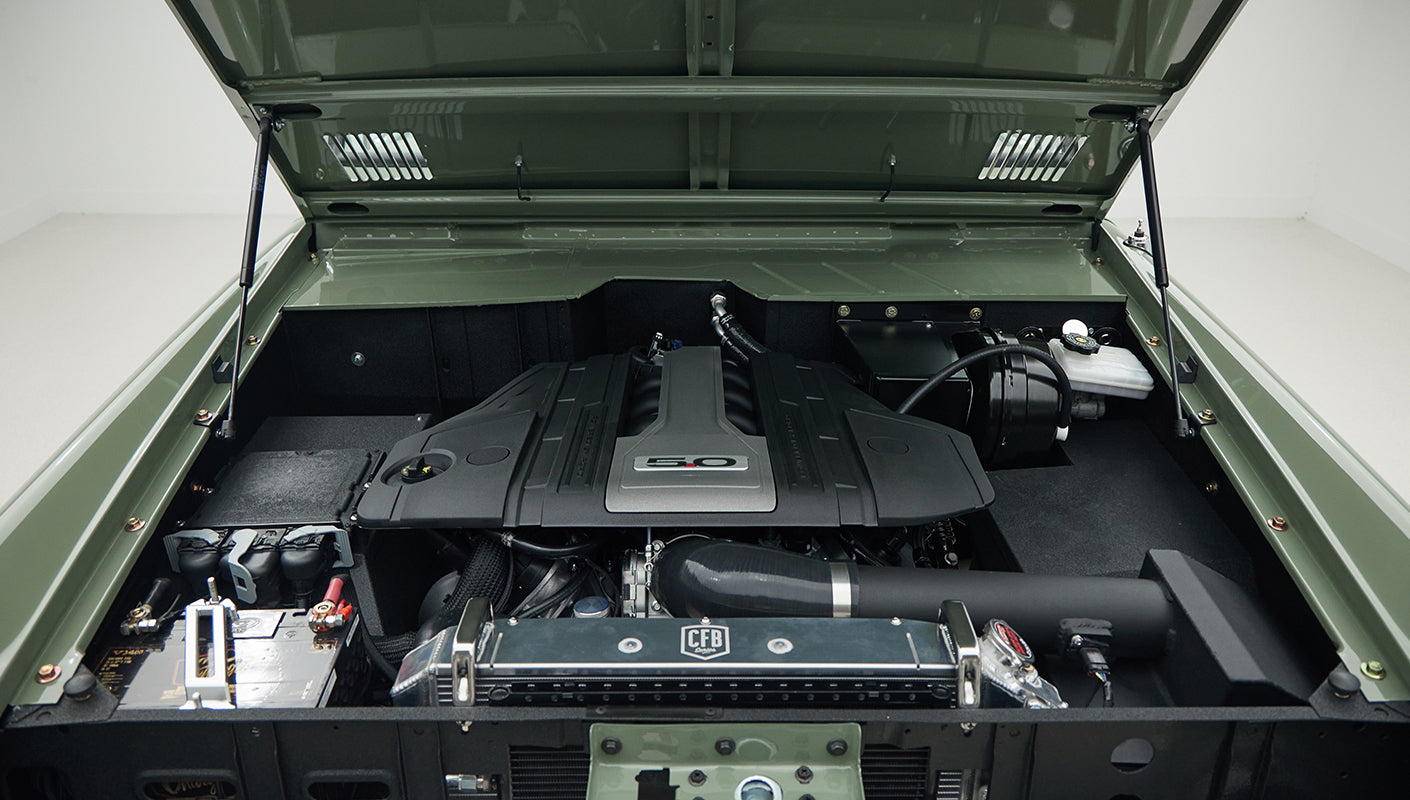 Open hood view showing engine compartment of a Classic Ford Bronco in Boxwood Green