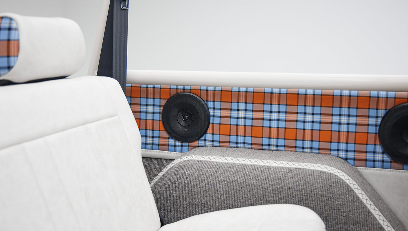 Classic Ford Bronco interior with white upholstery and orange blue plaid accents near speakers