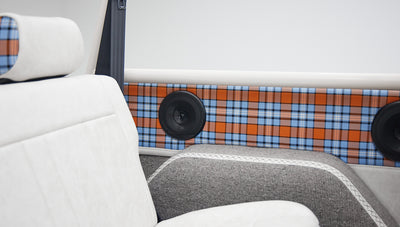 Classic Ford Bronco interior with white upholstery and orange blue plaid accents near speakers