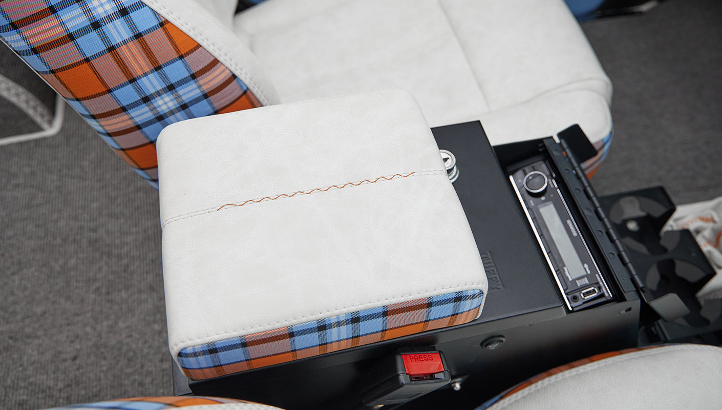 Close-up of white and orange blue plaid upholstery on armrest and part of seat in Classic Ford Bronco