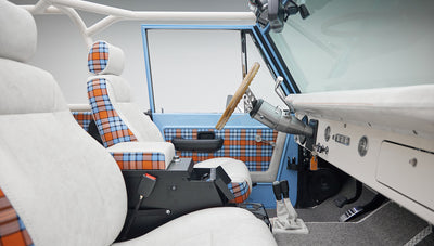 Side view of Classic Ford Bronco interior showing dashboard and seats with white and plaid covers