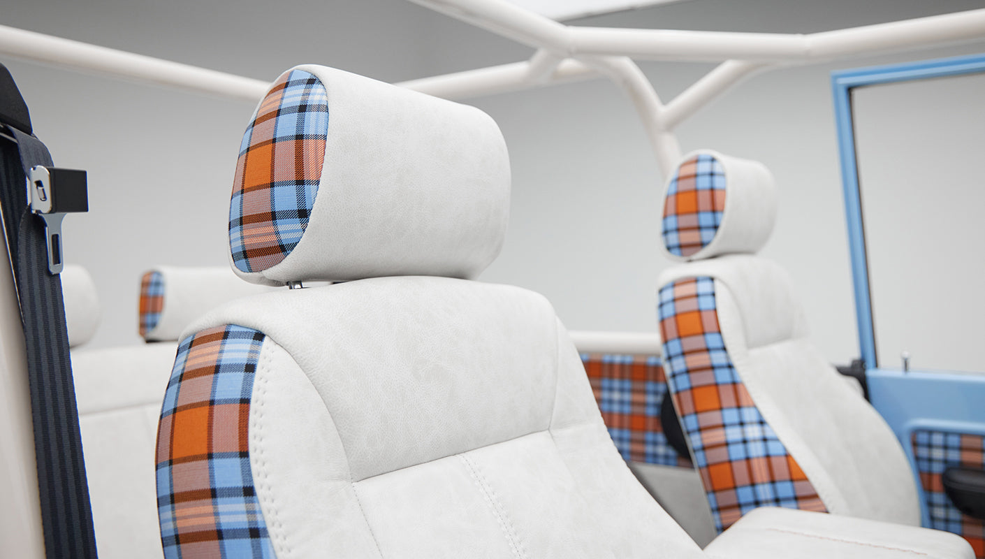 Classic Ford Bronco front seats with white upholstery and orange blue plaid headrests