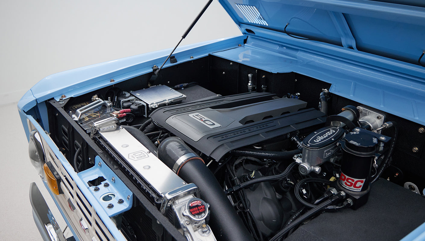 Close-up of 5.0 engine bay with visible Wilwood and PSC components in blue Classic Ford Bronco