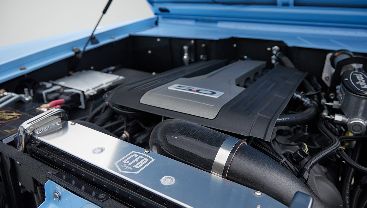 Detailed view of engine air intake with CFB logo in blue Classic Ford Bronco engine bay