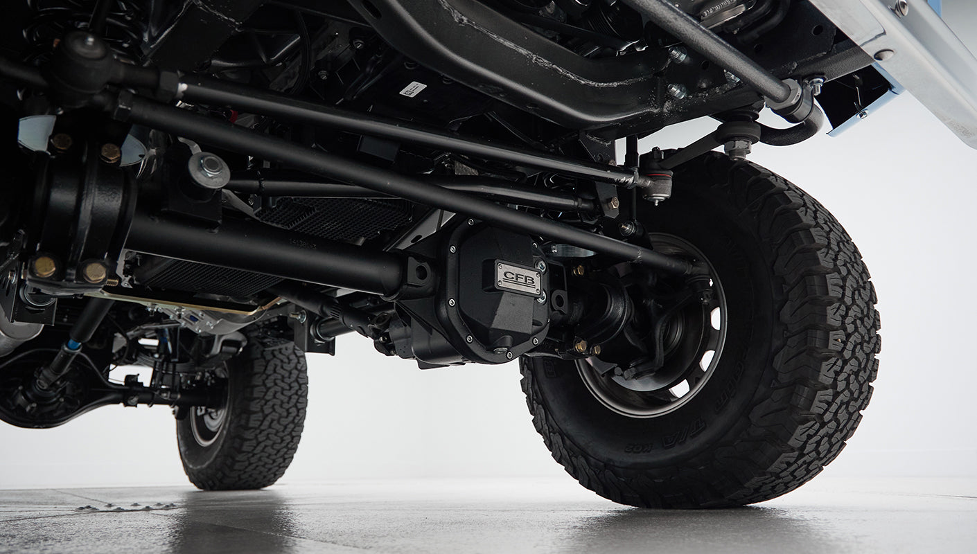 Underneath view of front axle, suspension, and tires of Classic Ford Bronco
