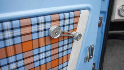 Plaid fabric and manual window crank handle on the inside of Classic Ford Bronco door