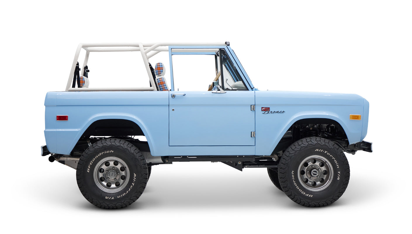 Classic Ford Bronco side profile in light blue with white roll bar and plain seats