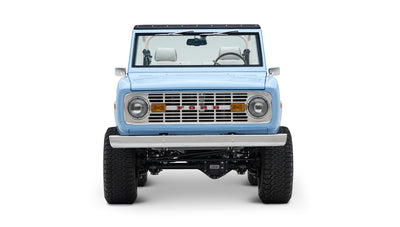 Classic Ford Bronco front view in light blue showing grille, headlights, and bumper