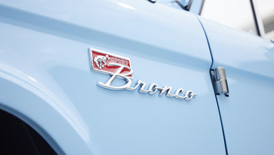 Close-up of Classic Ford Bronco sport emblem and blue paint finish