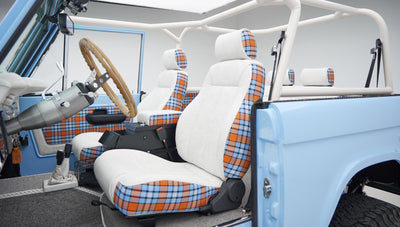 Interior view showing white and plaid seats and steering wheel inside Classic Ford Bronco