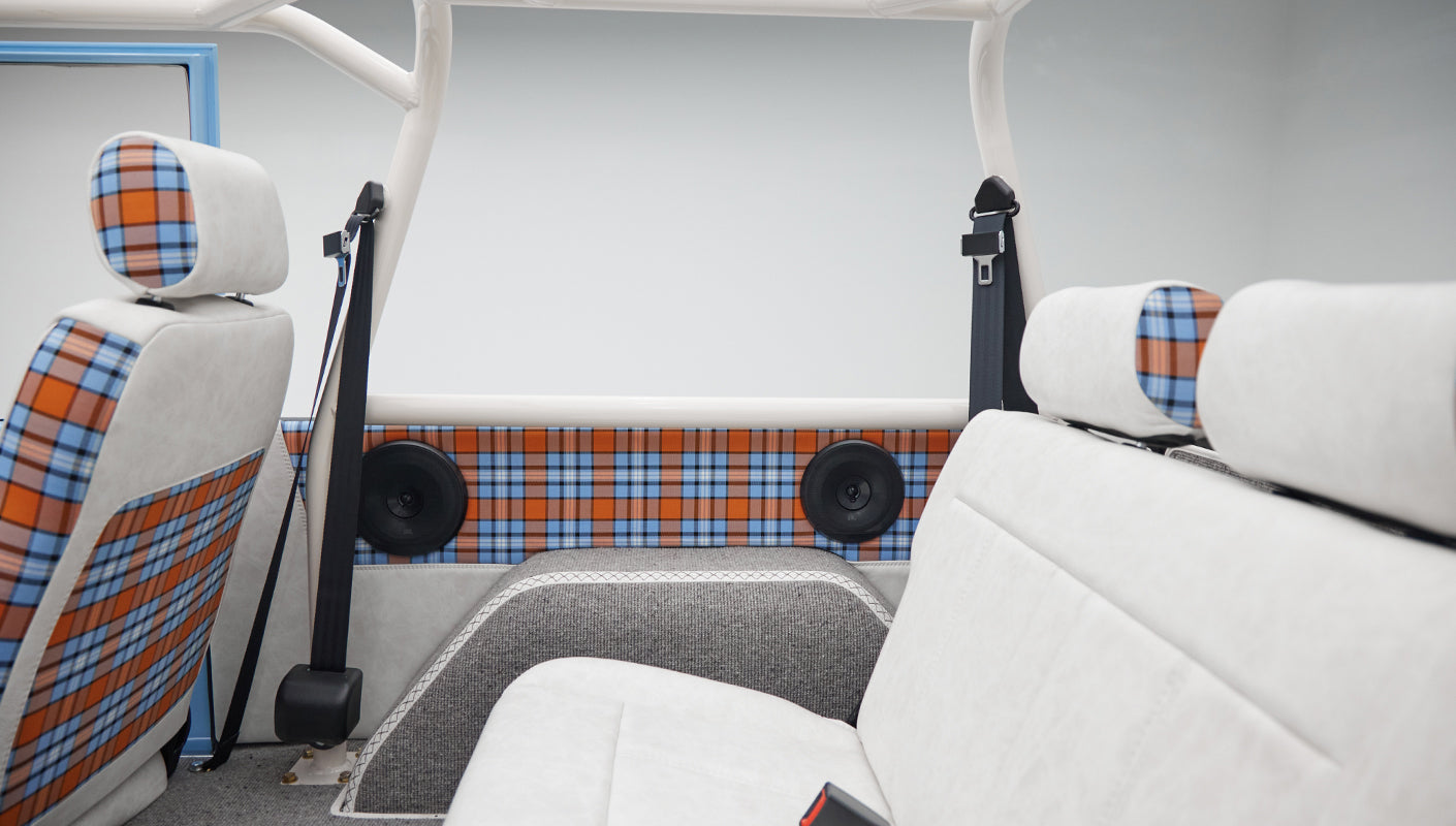 Classic Ford Bronco interior rear side showing plaid door panels and speakers