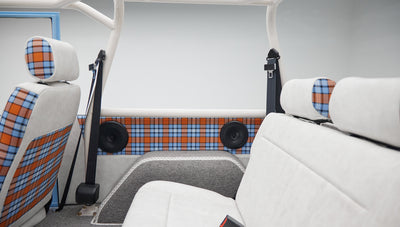 Classic Ford Bronco interior rear side showing plaid door panels and speakers