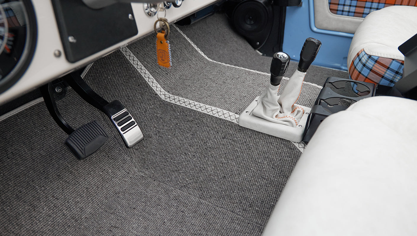 Floor pedals and gear levers in Classic Ford Bronco interior with gray carpet