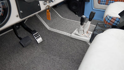 Floor pedals and gear levers in Classic Ford Bronco interior with gray carpet