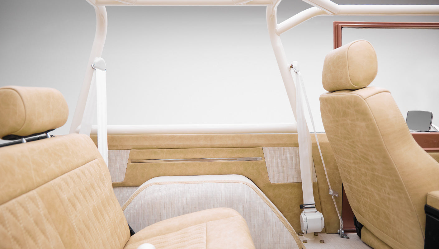 Beige upholstery and roll cage framing interior side panel of Classic Ford Bronco