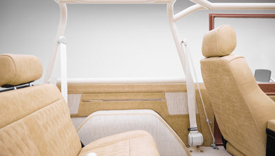 Beige upholstery and roll cage framing interior side panel of Classic Ford Bronco