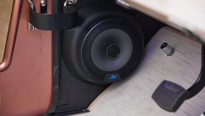 Car audio subwoofer speaker mounted inside Classic Ford Bronco's rear area