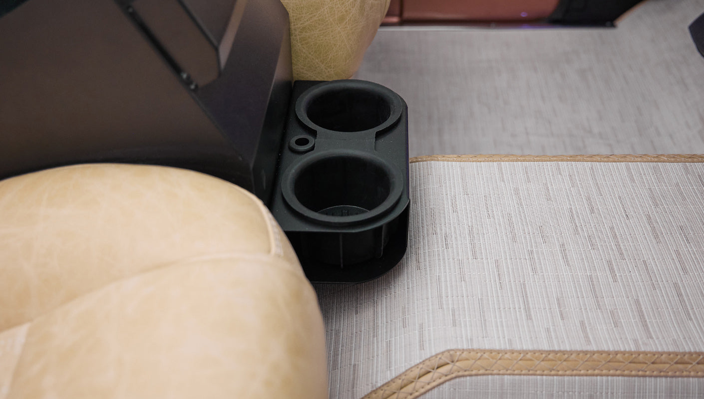 Center console cup holders next to beige leather seats in Classic Ford Bronco