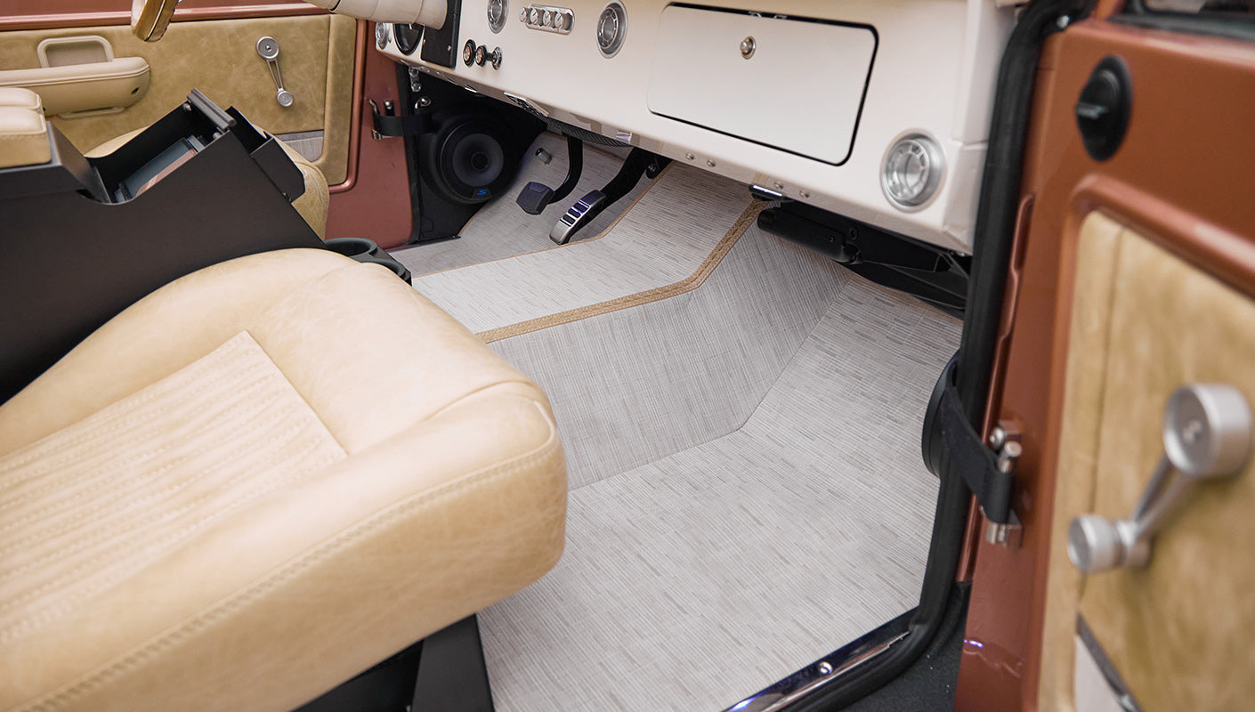 Front passenger seat area showing beige upholstery and tan carpet floor in Classic Ford Bronco