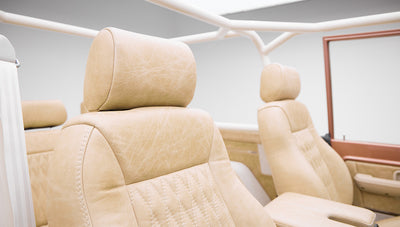 Front seats with beige leather upholstery and white roll bar inside Classic Ford Bronco
