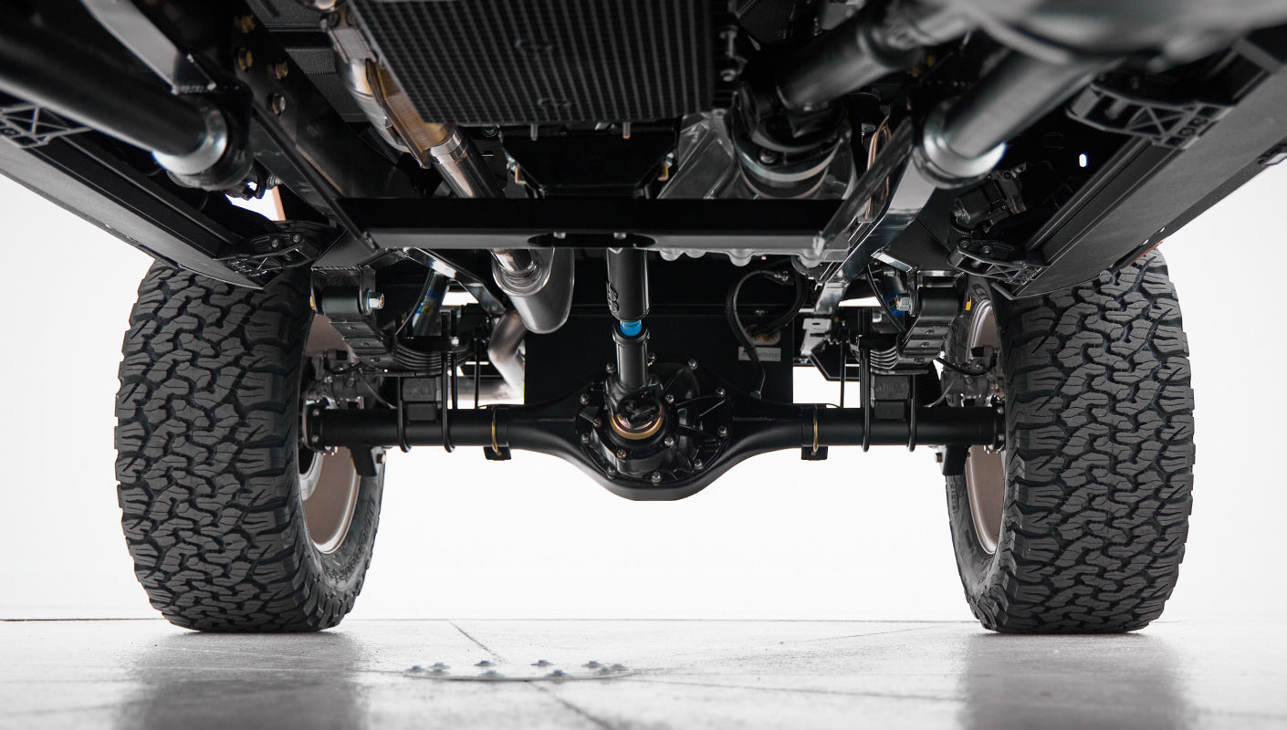 View of rear axle, suspension, and tires of a Classic Ford Bronco from ground level