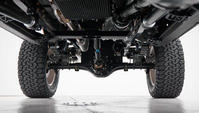 View of rear axle, suspension, and tires of a Classic Ford Bronco from ground level