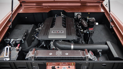 Detailed view of engine bay with installed components and brown hood edges of Classic Ford Bronco