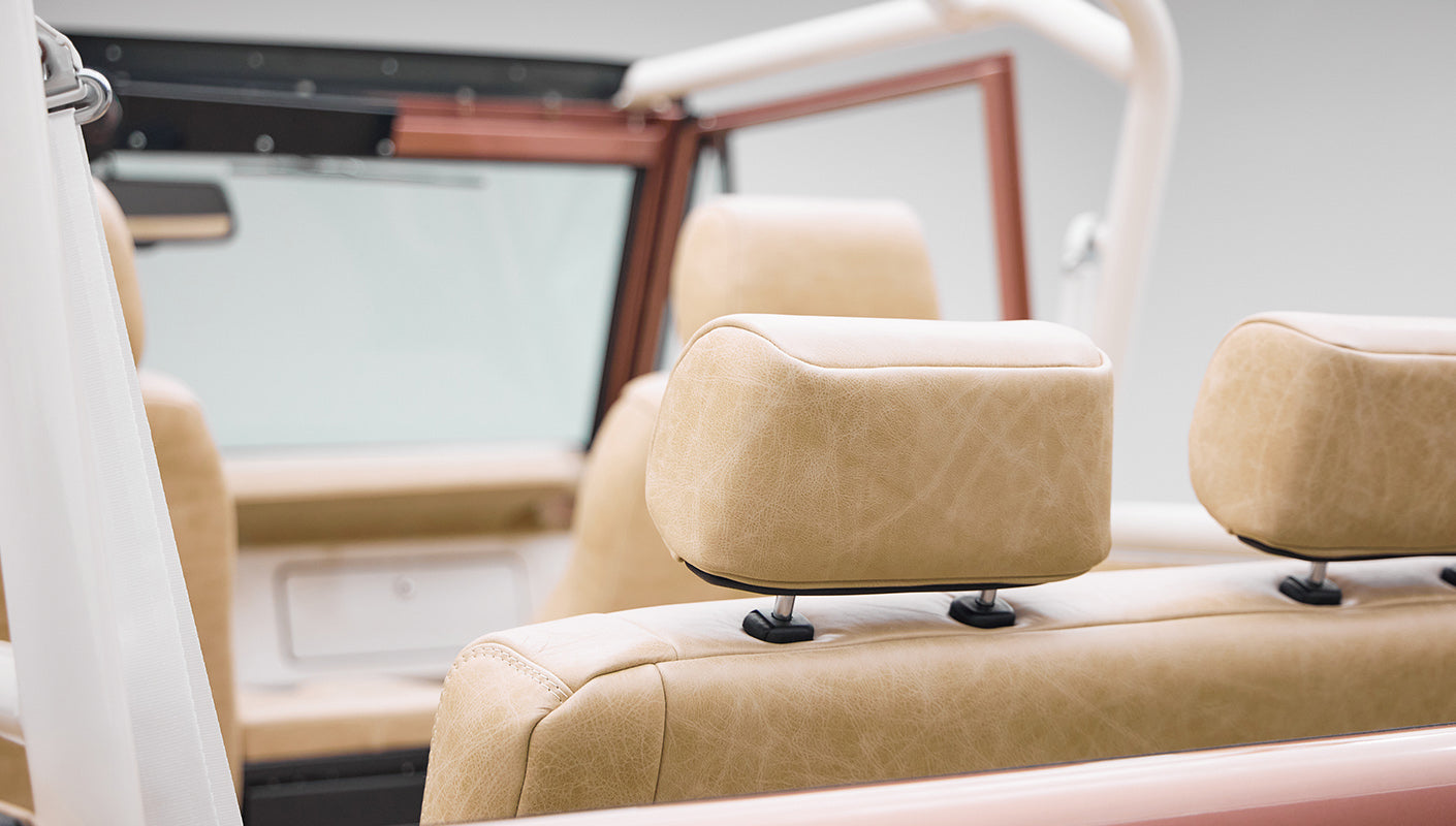 Close view of beige leather seats with headrests inside a Classic Ford Bronco