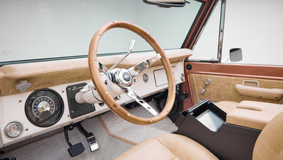 Classic Ford Bronco dashboard with wood steering wheel and speedometer