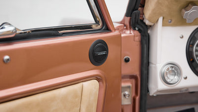 Speaker installation and beige interior upholstery on a door panel of a Classic Ford Bronco