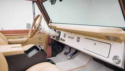 Classic Ford Bronco interior with beige seats and dashboard with steering wheel