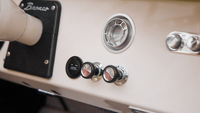 Close-up of Classic Ford Bronco dashboard controls including engine start button and knobs