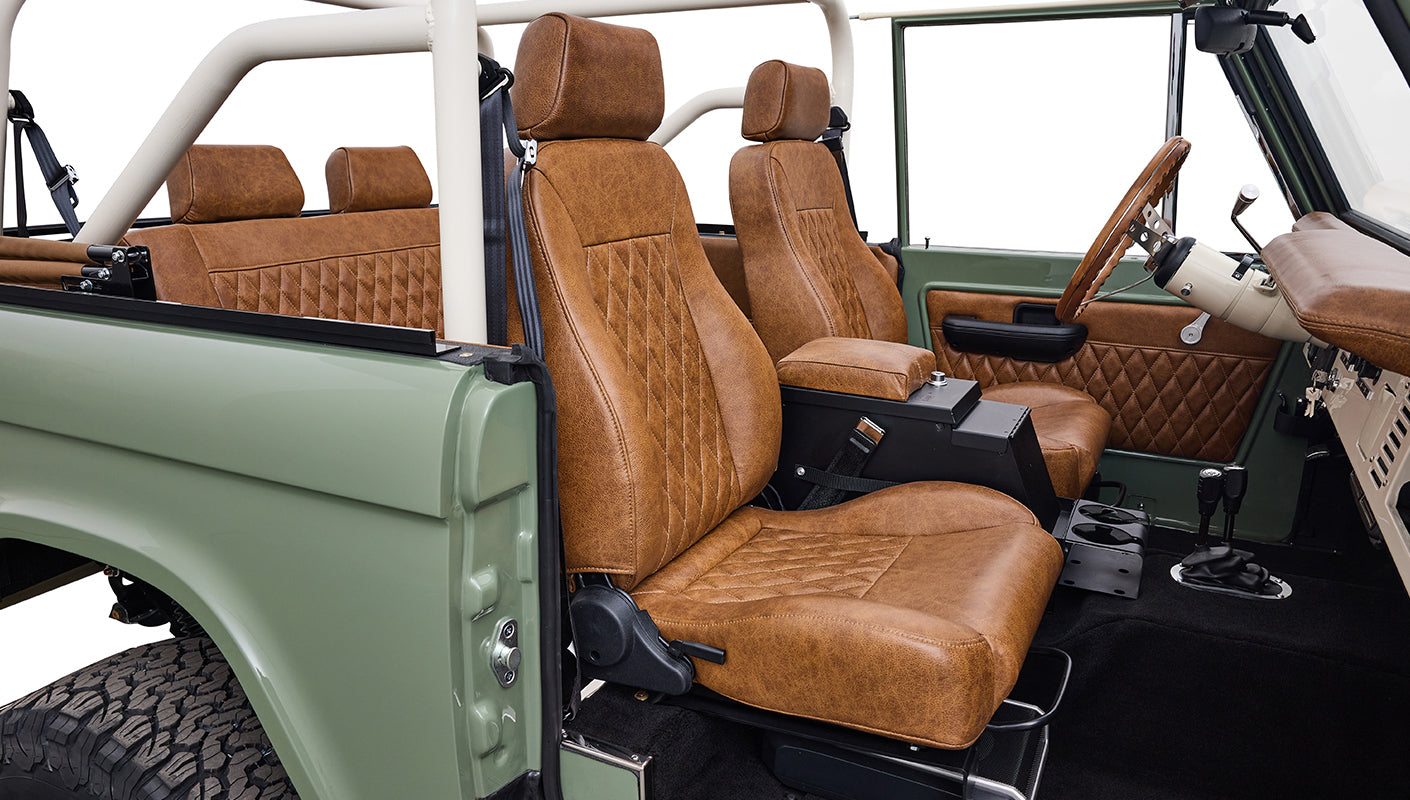 Side interior view of Classic Ford Bronco with diamond-stitched brown seats and door panel.