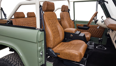 Side interior view of Classic Ford Bronco with diamond-stitched brown seats and door panel.