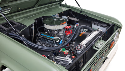 Engine bay of Classic Ford Bronco showing clean engine components and boxwood green paint.