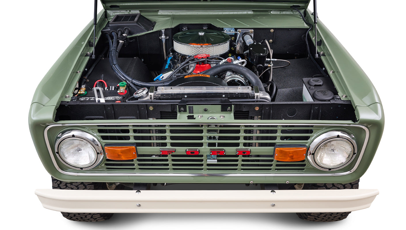 Front view of engine bay in Classic Ford Bronco with visible radiator and battery.