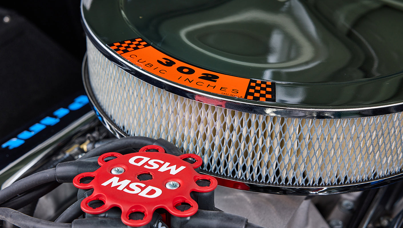 Close-up of air filter cover with 302 cubic inches decal and red MSD ignition component.