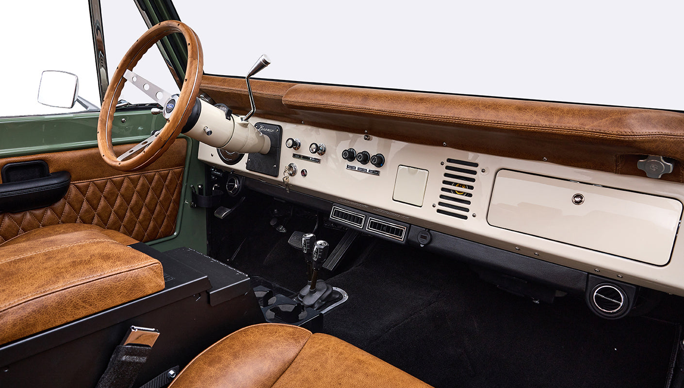 Dashboard and steering wheel of Classic Ford Bronco with brown leather and cream panel