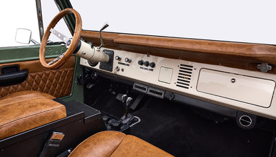 Dashboard and steering wheel of Classic Ford Bronco with brown leather and cream panel