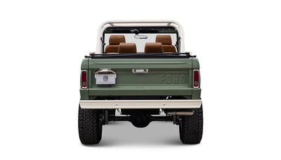 Rear view of Classic Ford Bronco in boxwood green showing tailgate, brown seats, and white bumper.