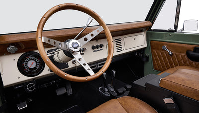 Wood steering wheel and cream dashboard with instrument cluster inside Classic Ford Bronco
