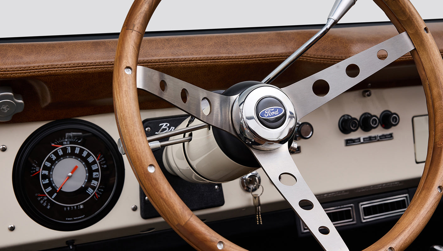 Close-up of wood steering wheel with Ford emblem at center inside Classic Ford Bronco