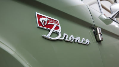 Close-up of Classic Ford Bronco emblem on boxwood green painted body.