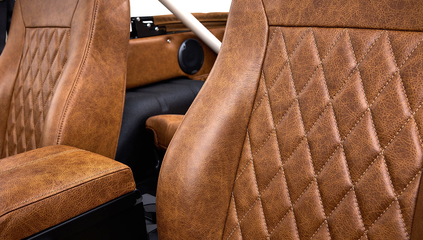 Close-up view of brown leather diamond-stitched seats and side panel inside Classic Ford Bronco