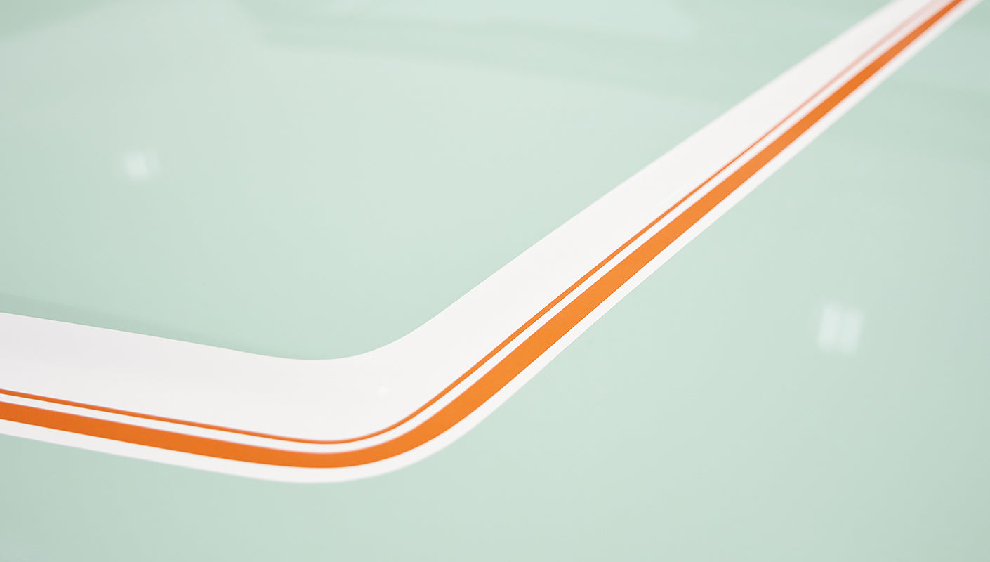 Close-up detail of hood corner with white and orange pinstriping on porcelain green paint of Classic Ford Bronco