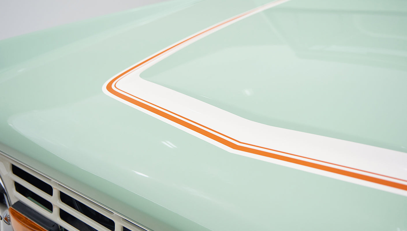 Close-up detail of hood with white and orange pinstriping on porcelain green paint of Classic Ford Bronco