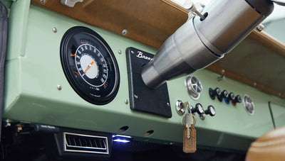 Dashboard view of classic Ford Bronco showing speedometer, vents, and key in ignition