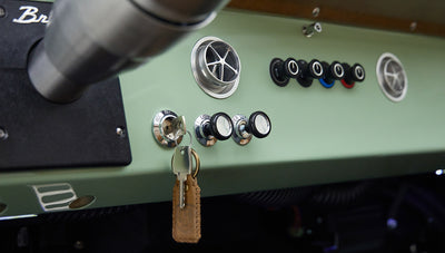 Close-up of dashboard controls and ignition key hanging from classic Ford Bronco interior
