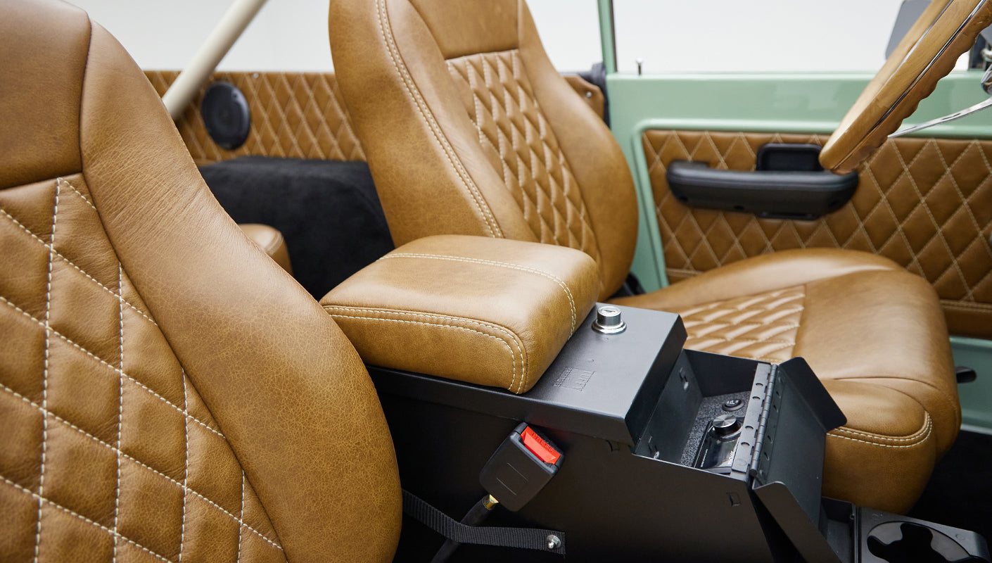 Leather front seats with visible seat belt and black center console inside vehicle